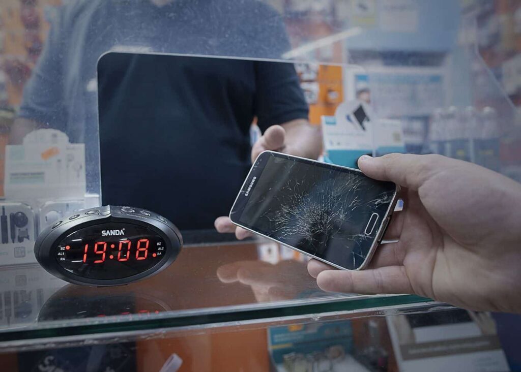 Cliente entregando un móvil con la pantalla rota para repararlo
